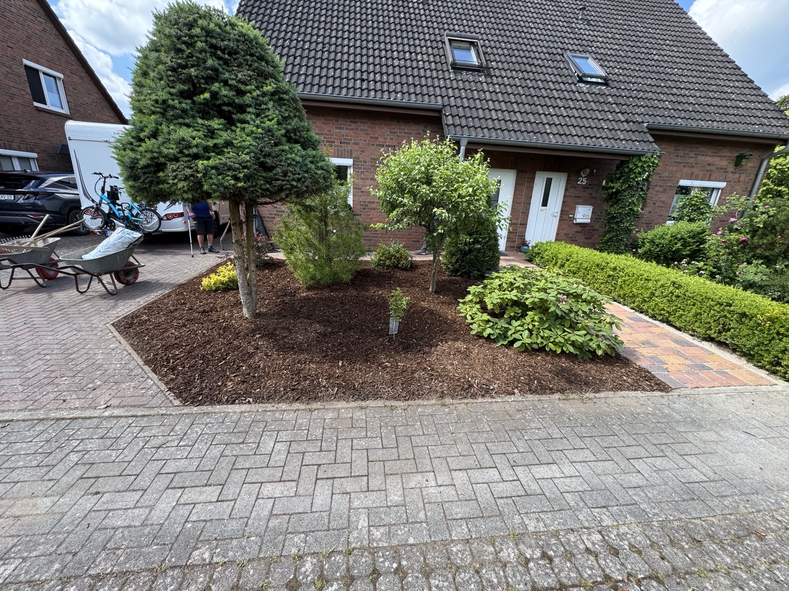 Bepflanztes Beet neben einer gepflasterten Fläche